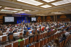 Keynote session at the ICBA Conference mainstage, 2025 with two large screens and crowd